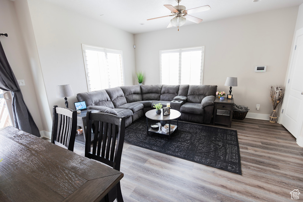 Living room featuring wood finished floors, baseboards, and a ceiling fan