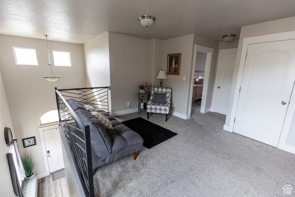 Sitting room with carpet flooring, an upstairs landing, and baseboards