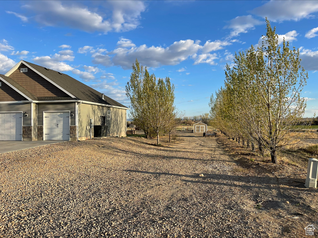 View of property exterior featuring an attached garage and driveway