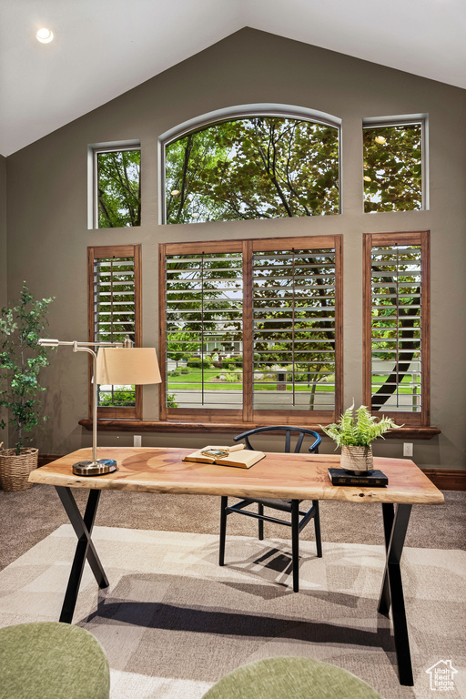 Living area with vaulted ceiling, carpet flooring, and healthy amount of natural light