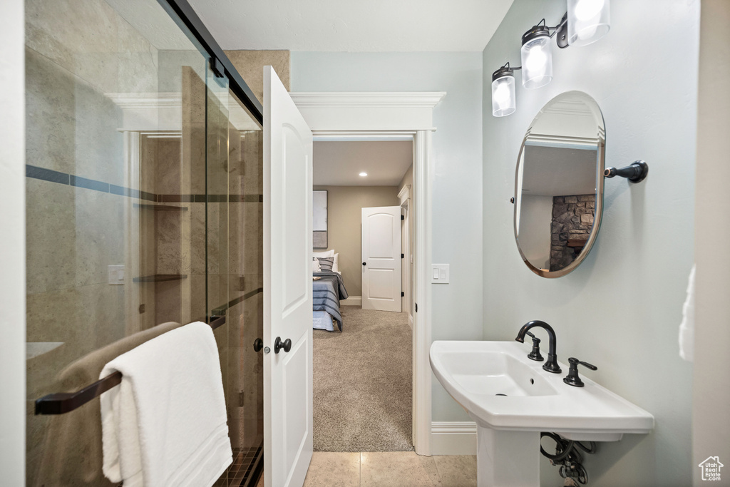 Bathroom with a stall shower and tile patterned floors