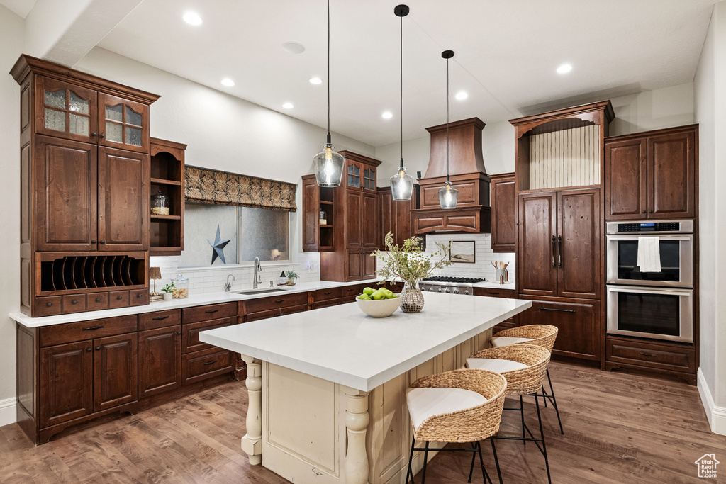 Kitchen featuring open shelves, double oven, tasteful backsplash, light countertops, and recessed lighting