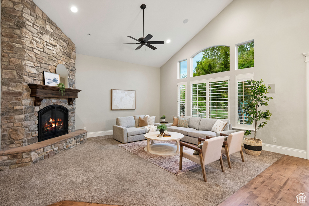 Living room with high vaulted ceiling, a fireplace, ceiling fan, wood finished floors, and recessed lighting