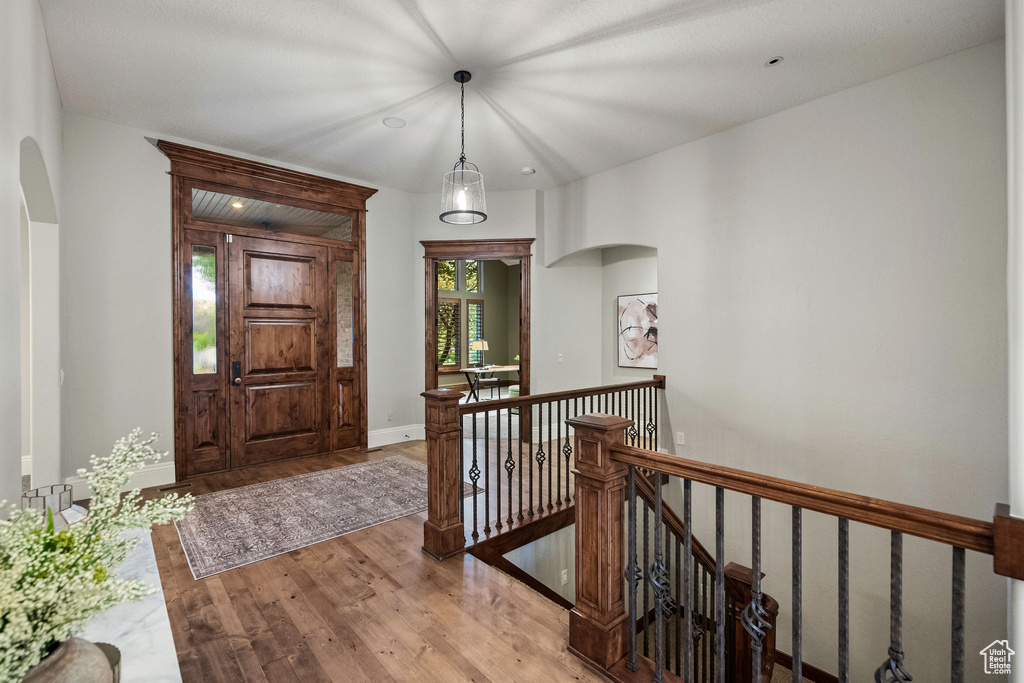 Foyer entrance with arched walkways and wood finished floors