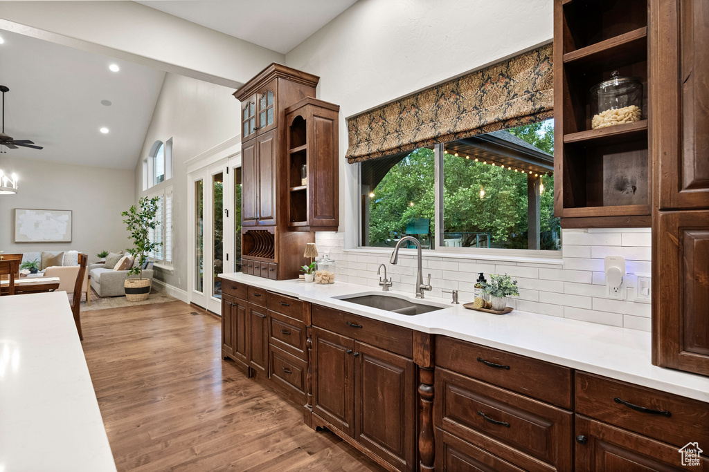 Kitchen with open shelves, light countertops, backsplash, healthy amount of natural light, and high vaulted ceiling