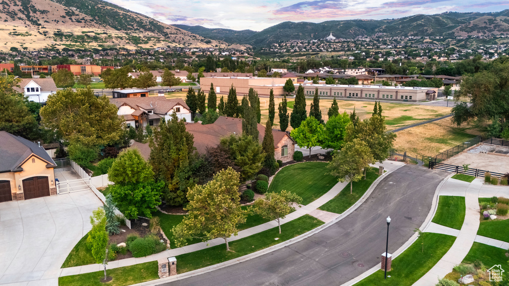 Aerial view of property and surrounding area with mountains and nearby suburban area