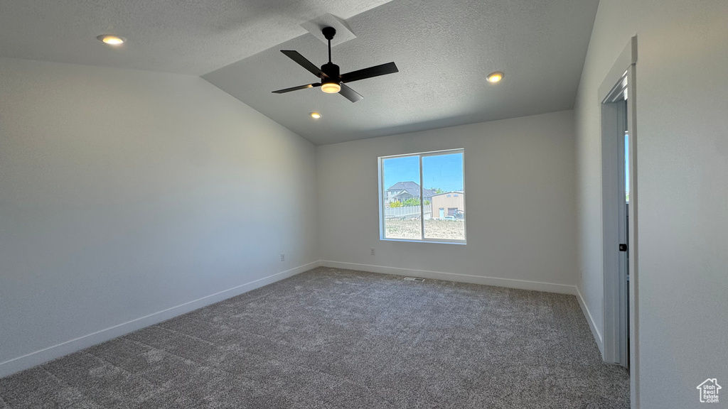 Empty room with carpet, lofted ceiling, ceiling fan, baseboards, and recessed lighting