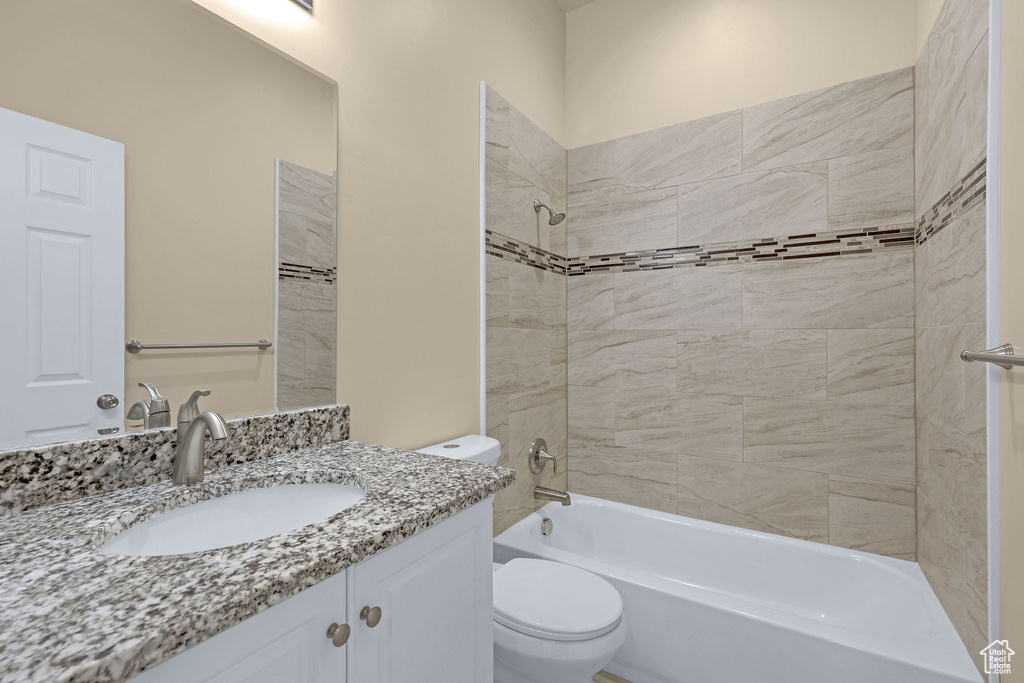 Bathroom with vanity,  shower combination, and toilet
