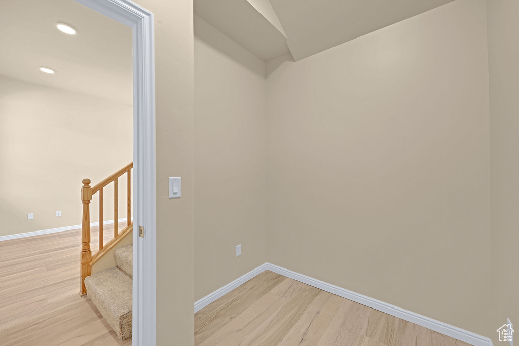 Spare room with light wood finished floors, baseboards, stairs, and recessed lighting