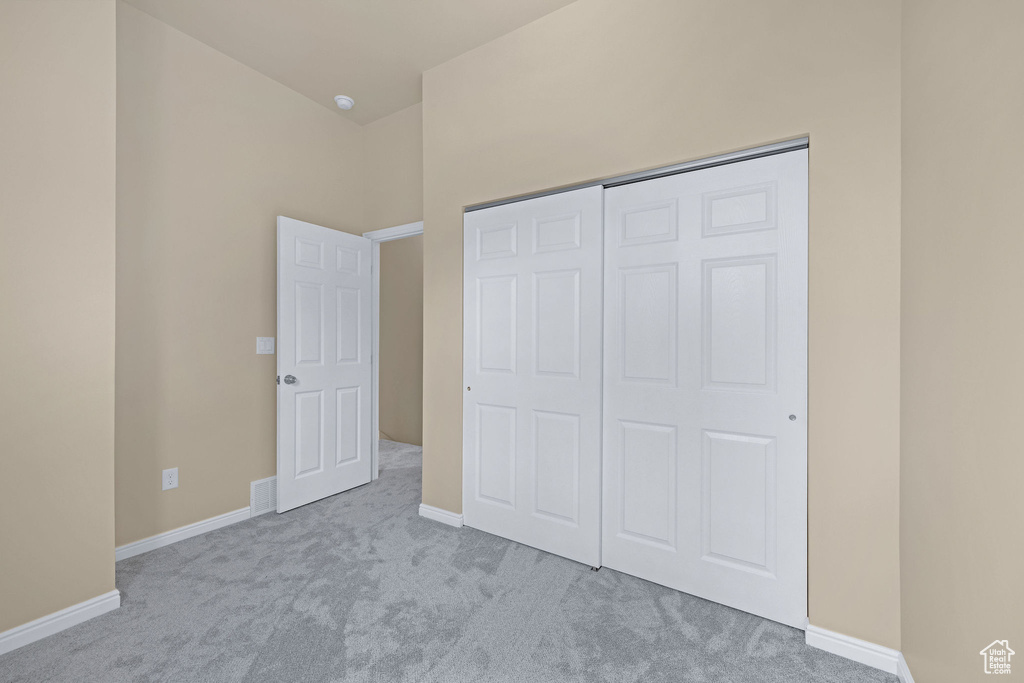 Unfurnished bedroom featuring a closet, visible vents, baseboards, and carpet floors