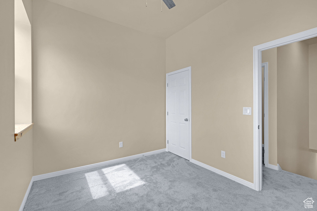 Carpeted spare room with baseboards and a ceiling fan