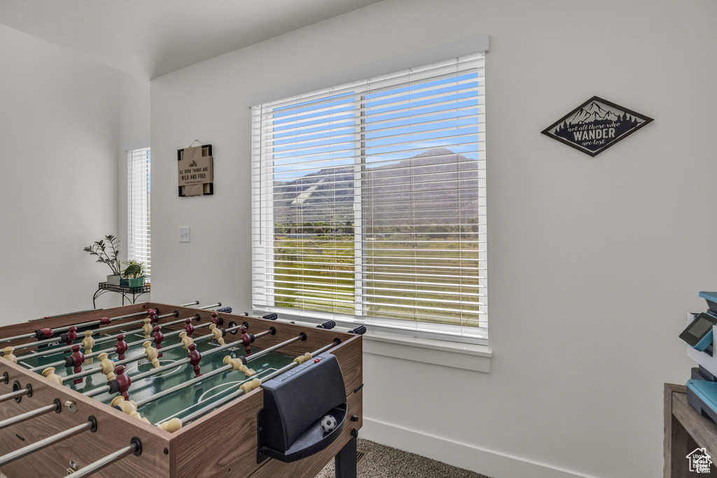 Recreation room featuring baseboards and carpet floors
