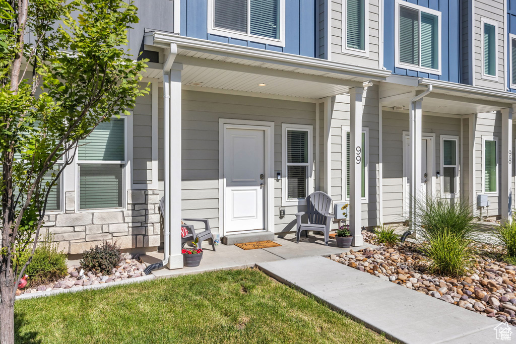 View of exterior entry featuring stone siding and covered porch
