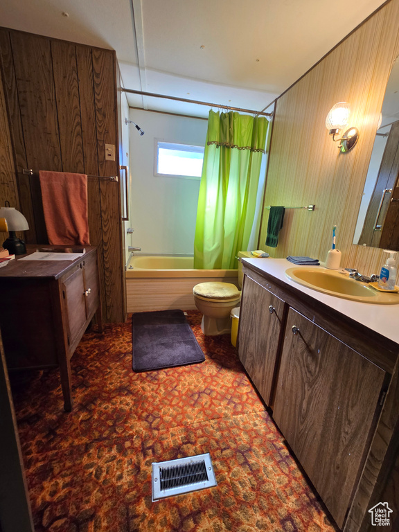 Bathroom featuring vanity, toilet, shower / bathtub combination with curtain, and wooden walls