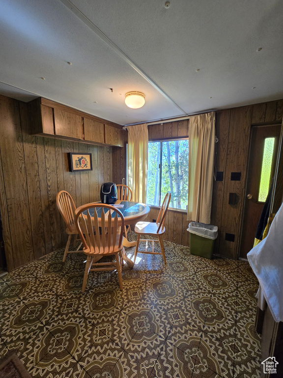 Dining area with wooden walls and plenty of natural light
