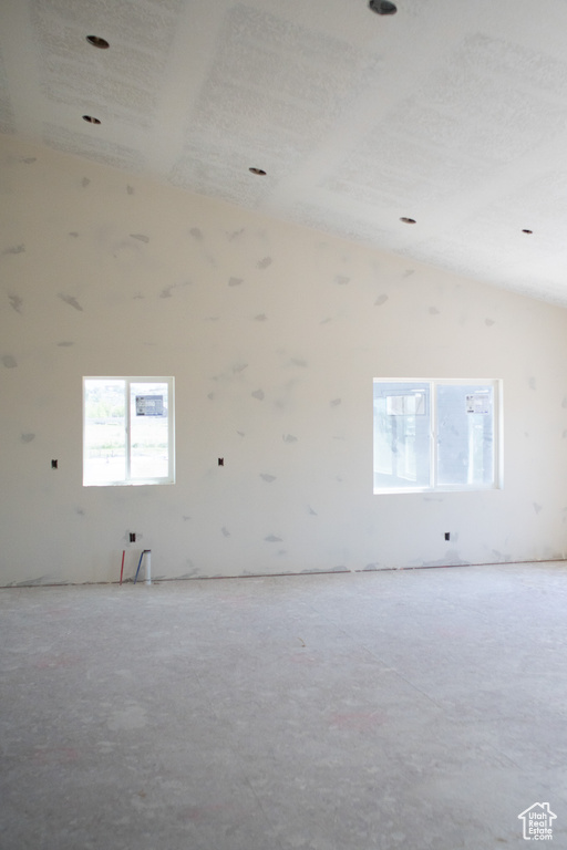 Unfurnished room featuring vaulted ceiling
