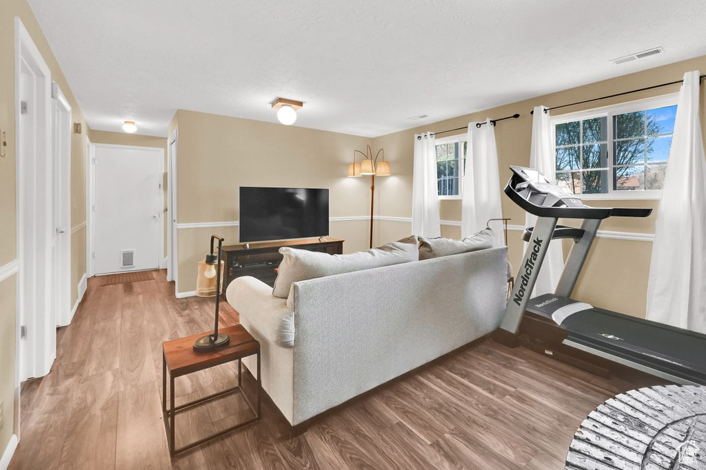 Living room featuring wood finished floors, baseboards, and visible vents