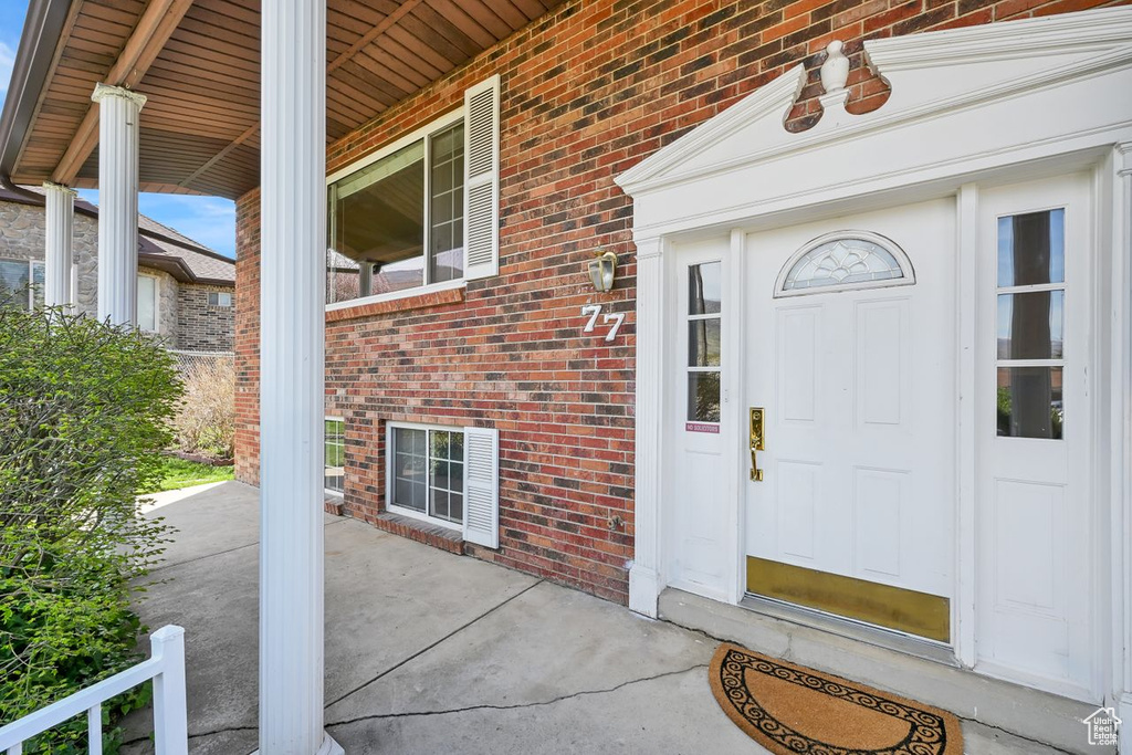 Property entrance with brick siding and a porch