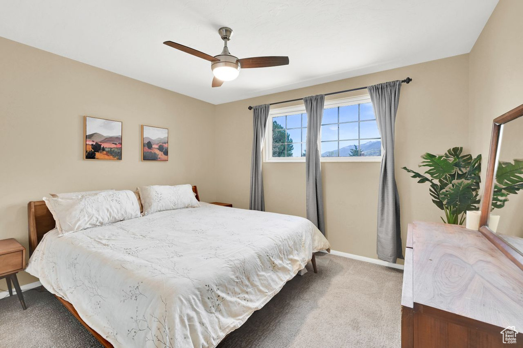 Bedroom featuring baseboards, a ceiling fan, and carpet