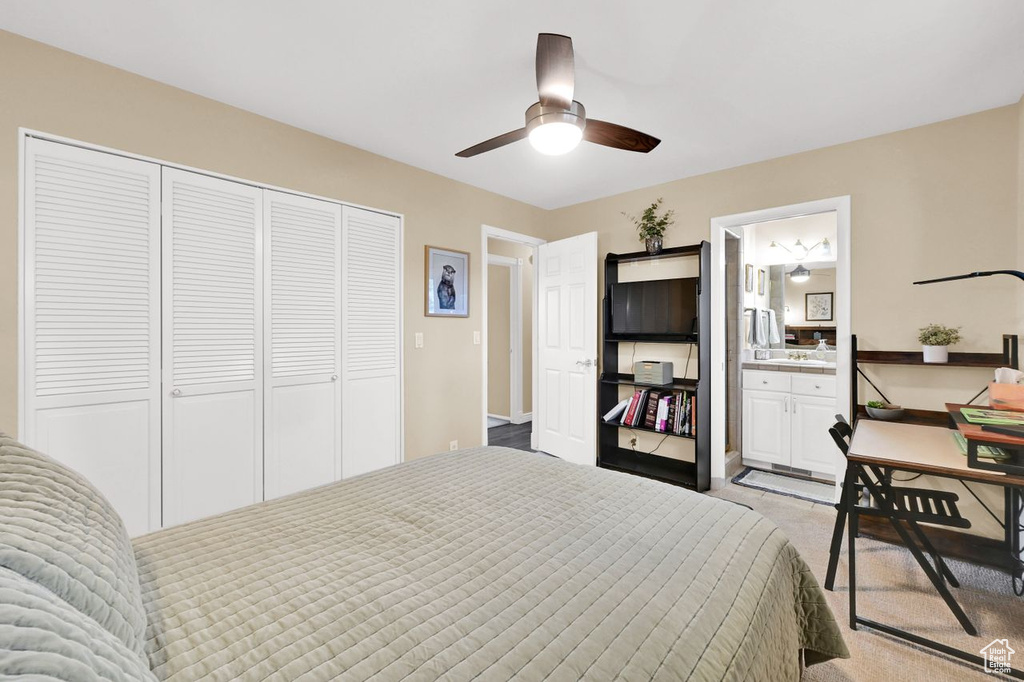 Carpeted bedroom featuring a closet, baseboards, connected bathroom, and ceiling fan