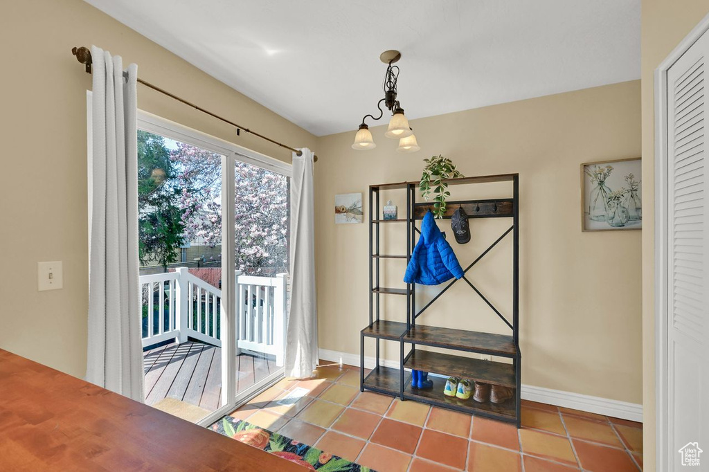 Doorway to outside featuring baseboards and tile patterned flooring