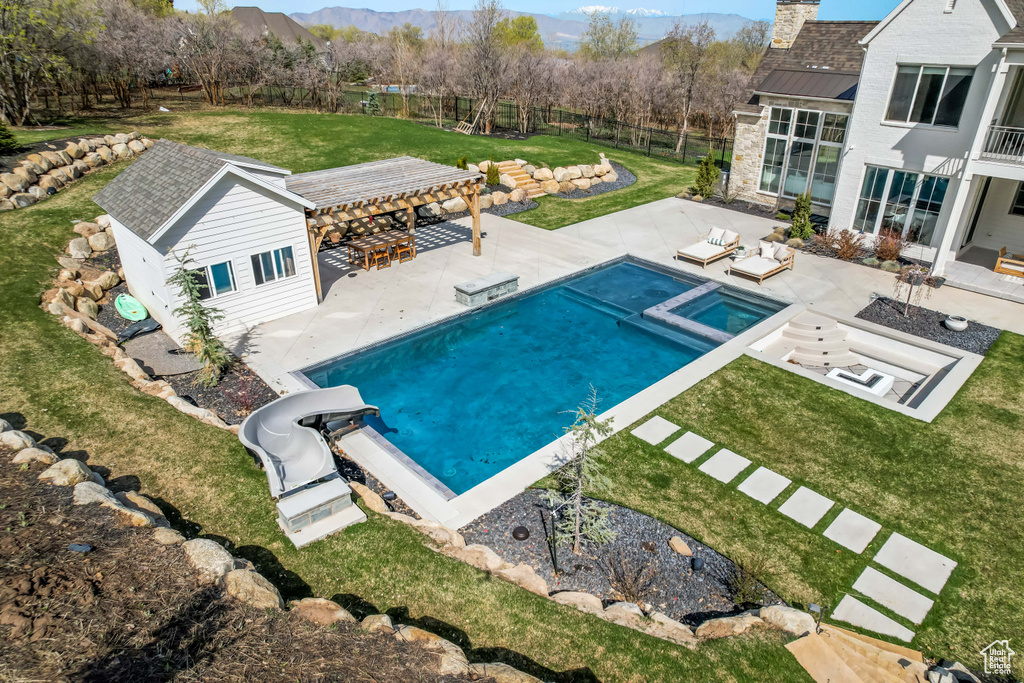 Swimming pool with outdoor lounge area, a patio, a pergola, and a mountain view