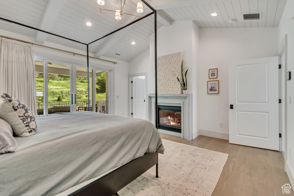 Bedroom featuring light wood-style flooring, access to outside, baseboards, recessed lighting, and a glass covered fireplace