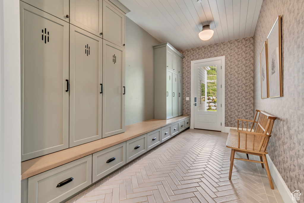 Mudroom with wallpapered walls and baseboards