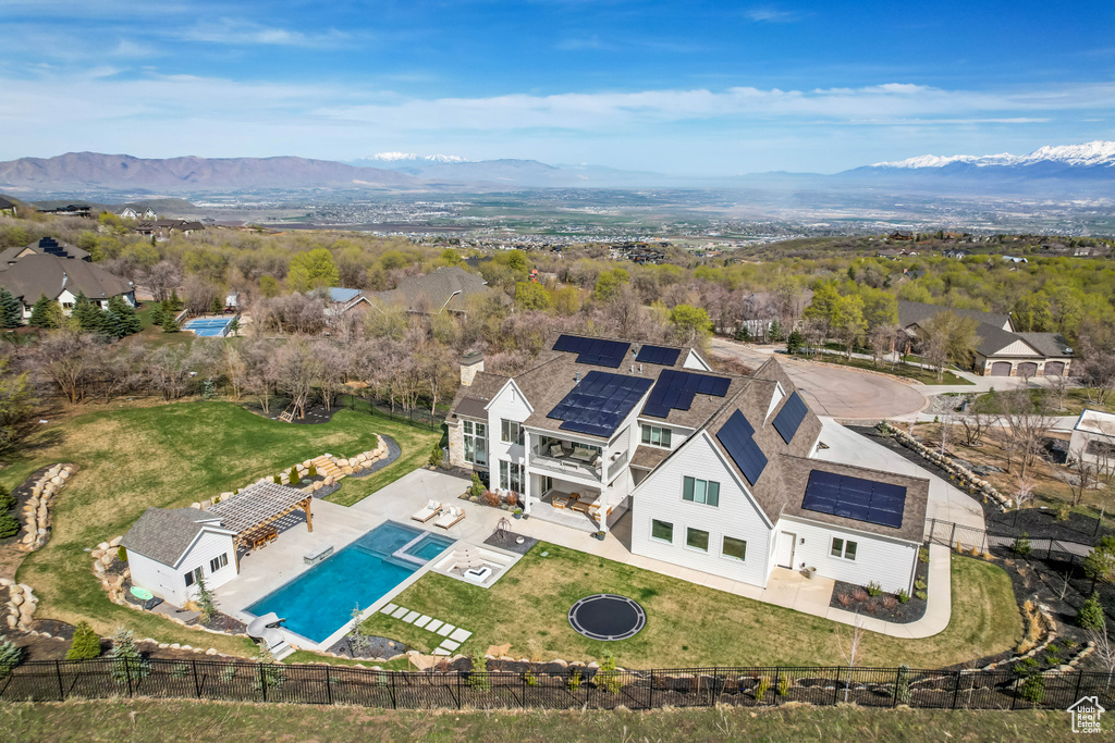 View of subject property with a mountainous background and a pool