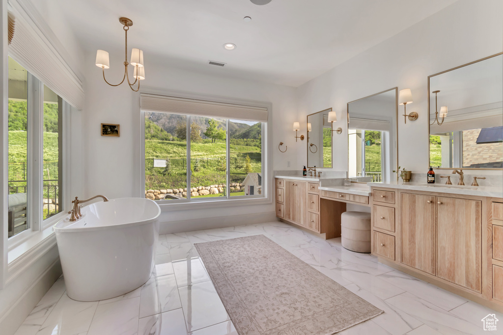 Full bathroom featuring marble look tile flooring, a freestanding tub, vanity, recessed lighting, and baseboards