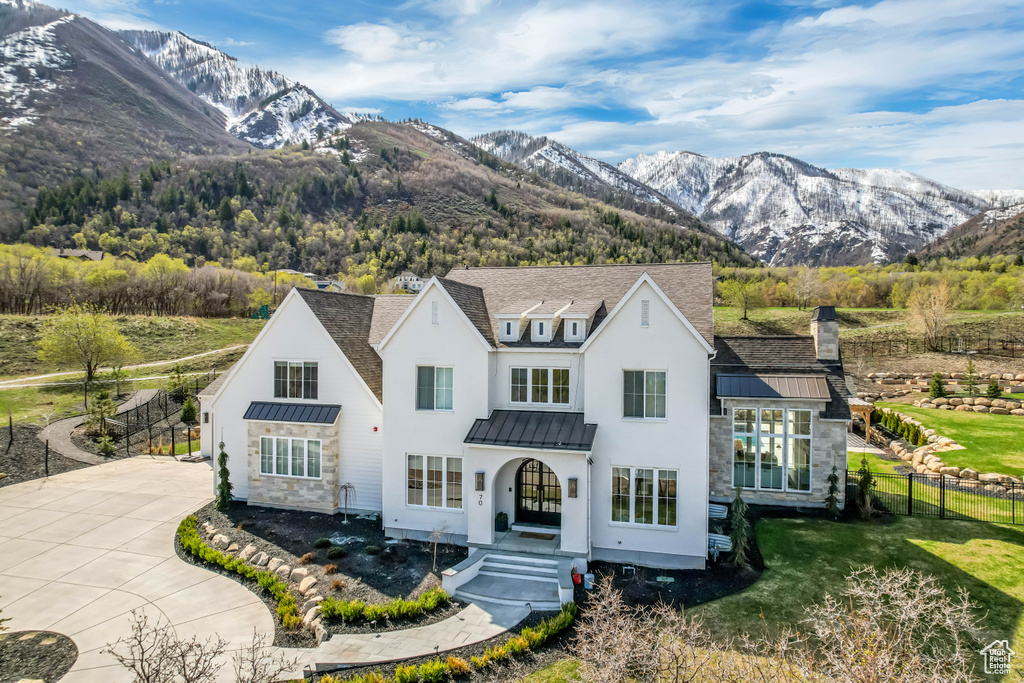 View of front of house featuring a standing seam roof, stucco siding, and a mountain view