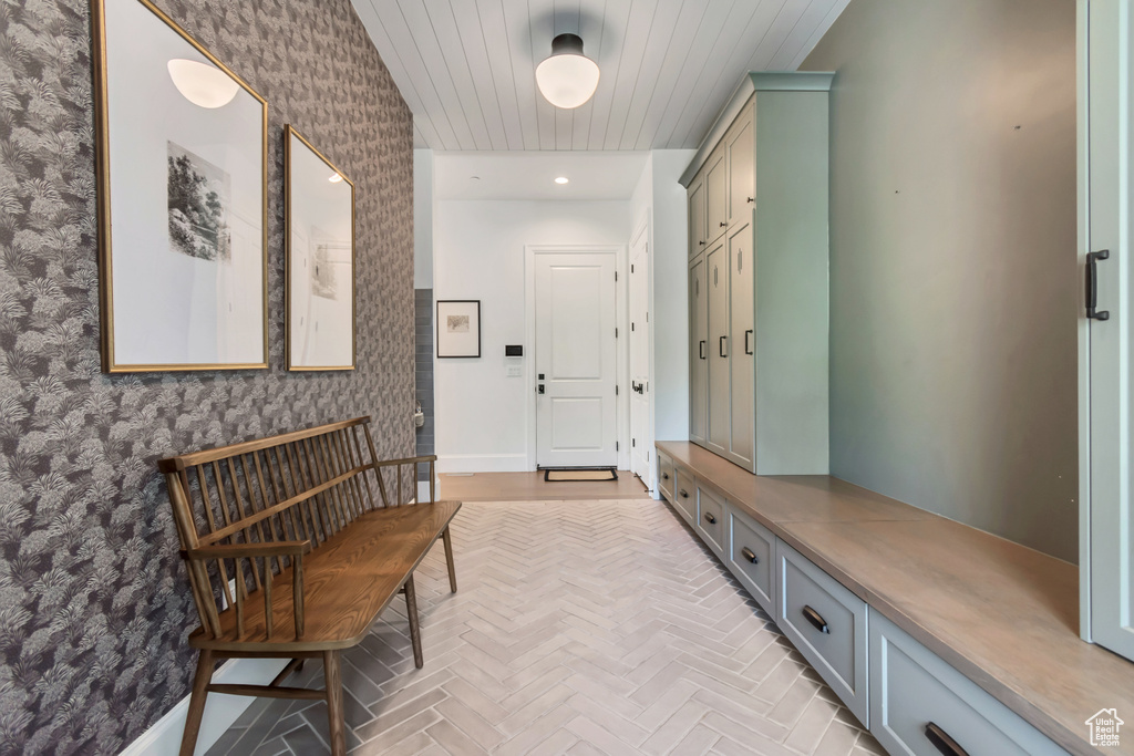 Mudroom with wallpapered walls and baseboards