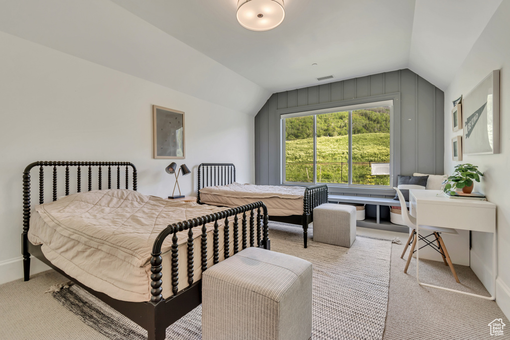 Bedroom featuring vaulted ceiling, carpet flooring, and baseboards