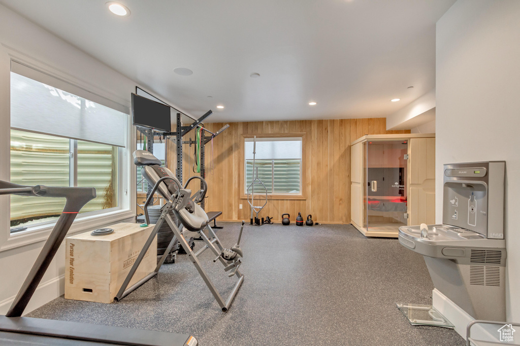 Exercise area featuring wood walls, recessed lighting, and baseboards