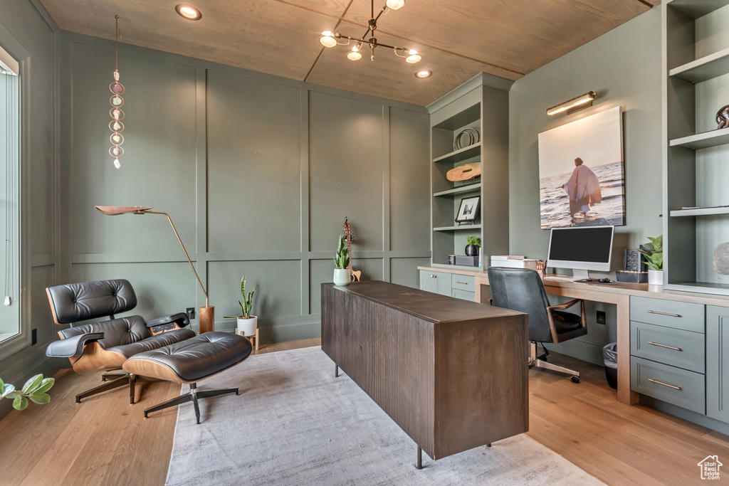 Office featuring light wood-style floors, built in features, built in study area, a decorative wall, and recessed lighting