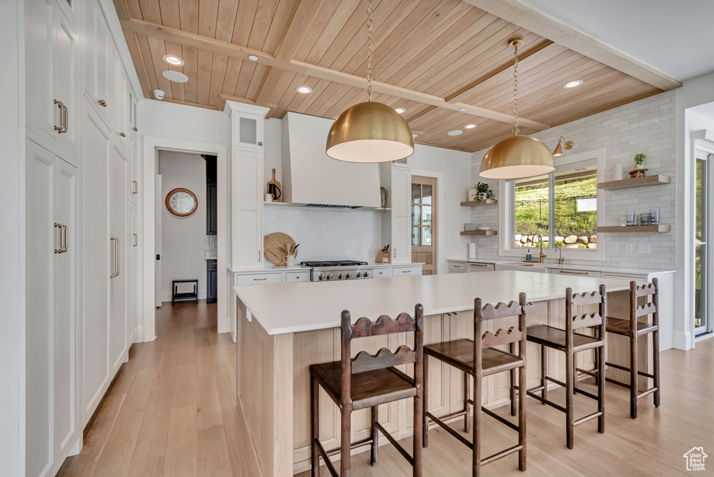 Kitchen featuring open shelves, wood ceiling with exposed beams, premium range hood, backsplash, and light countertops