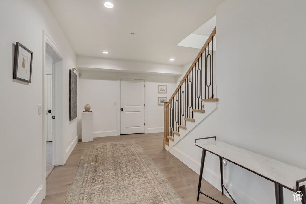 Entryway featuring recessed lighting, light wood-style flooring, stairs, and baseboards