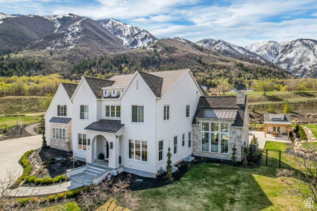 View of front of house featuring a standing seam roof, metal roof, stone siding, and a mountain view