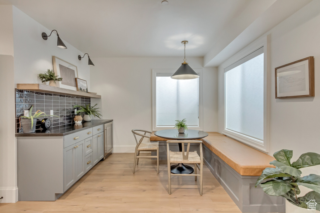 Dining room featuring light wood-style floors, beverage cooler, baseboards, and breakfast area
