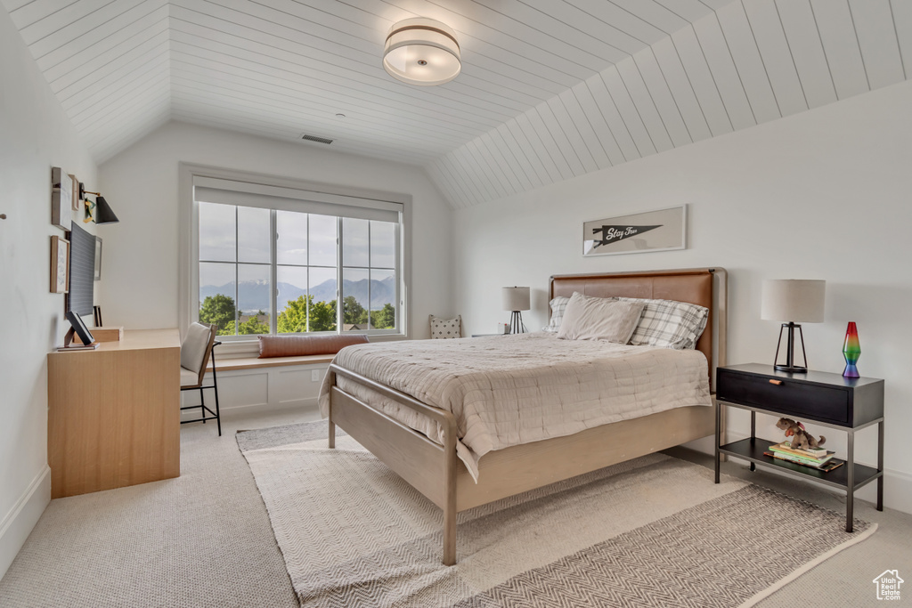 Bedroom featuring light carpet and lofted ceiling