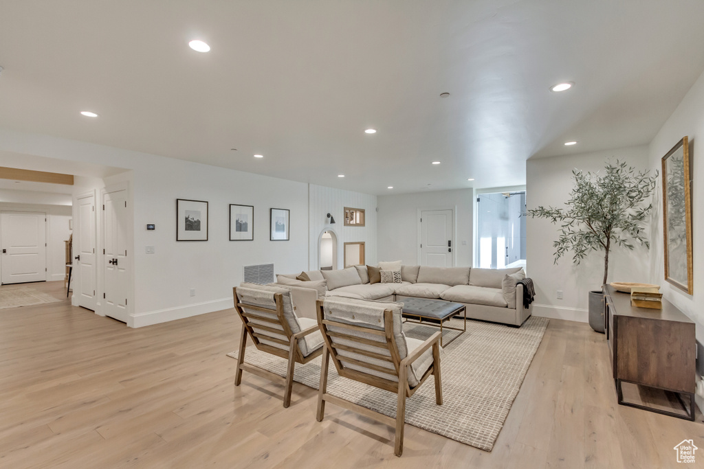 Living area with light wood-style flooring, baseboards, and recessed lighting