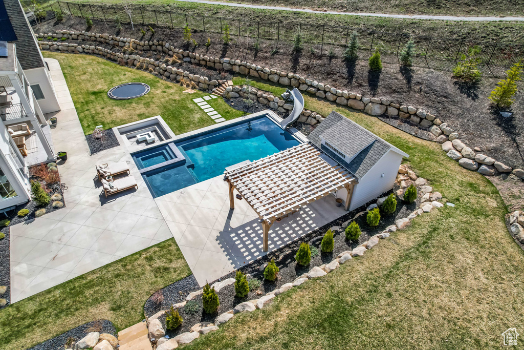 View of pool featuring a water slide, a patio area, and a pool with connected hot tub