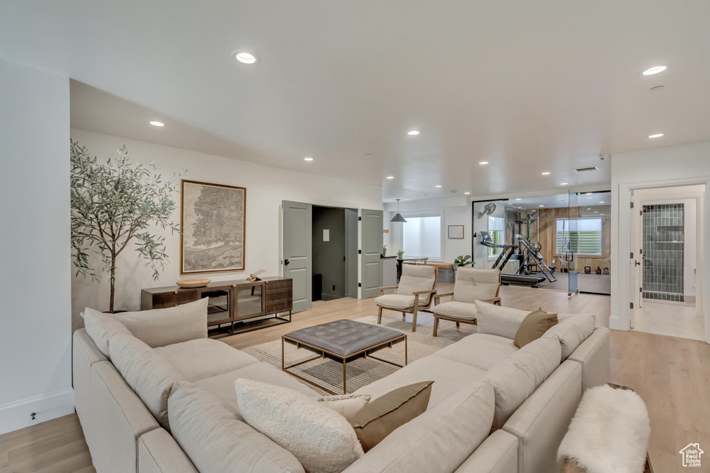 Living room featuring light wood-type flooring, recessed lighting, and baseboards