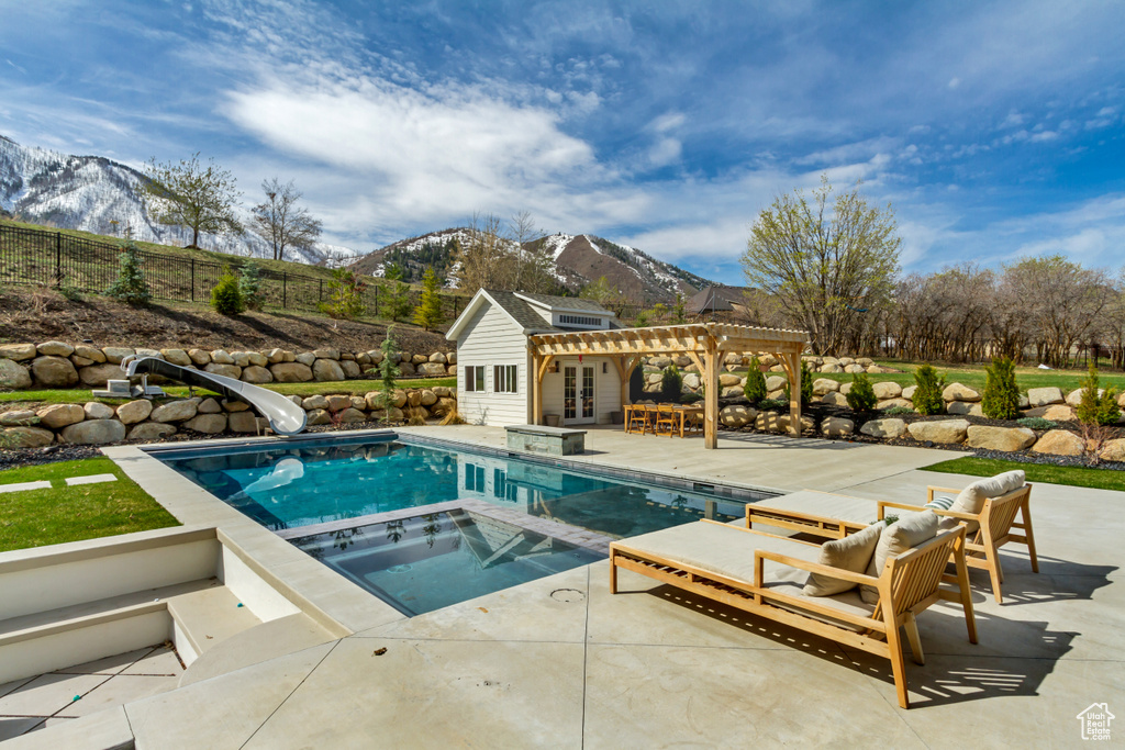 View of pool featuring a mountain view, a pergola, a patio, and french doors