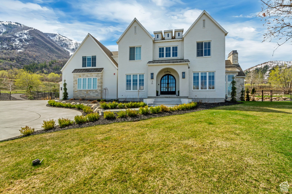View of front of house featuring a standing seam roof, metal roof, a mountain view, and stucco siding