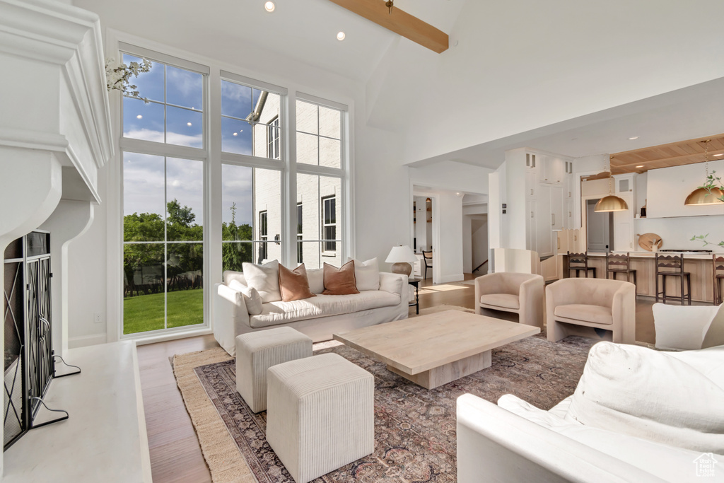 Living room featuring a towering ceiling, light wood-style flooring, and recessed lighting