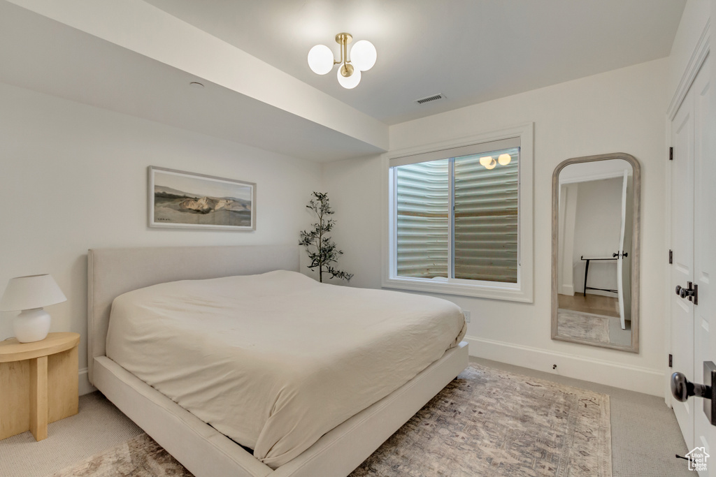 Bedroom with light colored carpet and baseboards
