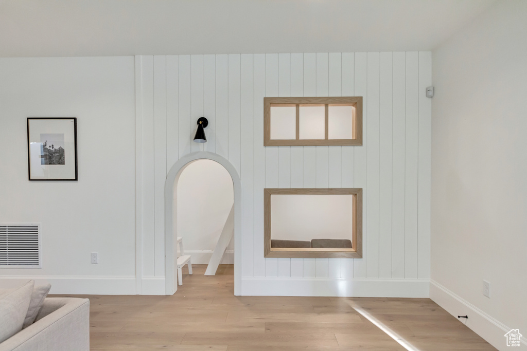 Unfurnished living room featuring wood finished floors and baseboards