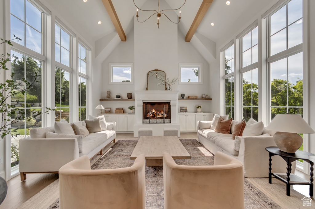 Living area featuring high vaulted ceiling, beam ceiling, light wood-type flooring, a fireplace, and recessed lighting