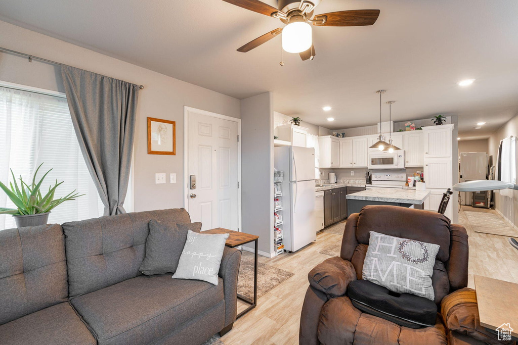 Living room featuring light wood-style flooring, a ceiling fan, and recessed lighting